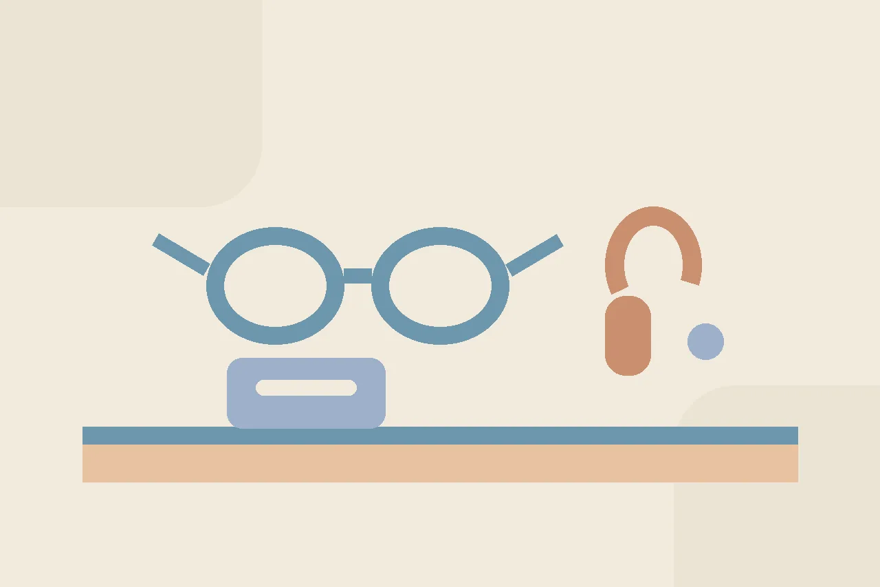 Abstract flat illustration in warm muted tones showing a pair of rounded eyeglass shapes and a small curved hearing aid form resting on a soft desk plane beside a labeled case.
